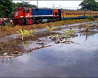 A train travels past seeping mud in Sidoarjo, Indonesia, December 2006. Hundreds of residents whose houses have been submerged by a 